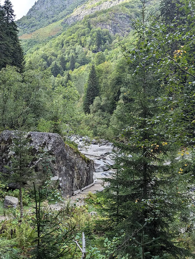 Dolra River valley with wooden footbridge on the trail to Mount Ushba